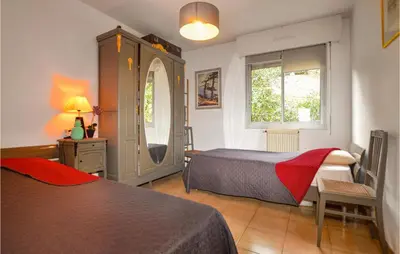 a bedroom with two beds and a dresser and a window at Cozy Apartment In Ajaccio With Wifi in Ajaccio