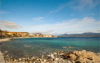 a beach with rocks and buildings in the water at Cozy Apartment In Ajaccio With Wifi in Ajaccio