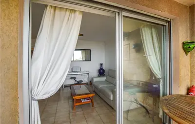 a living room with a couch and a sliding glass door at Cozy Apartment In Ajaccio With Wifi in Ajaccio