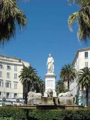 a statue in front of a building with palm trees at Appartement Hypercentre Parking Gratuit in Ajaccio