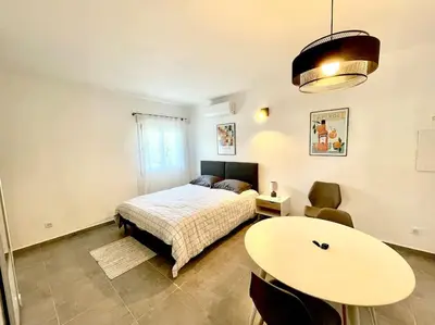 a bedroom with a bed and a table at Appartement Hypercentre Parking Gratuit in Ajaccio