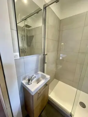 a white bathroom with a sink and a shower at Appartement Hypercentre Parking Gratuit in Ajaccio