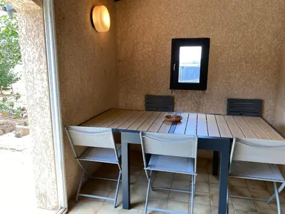a dining room table with chairs and a mirror at Casa Minnana in Figari