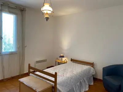 a bedroom with a bed and a chair and a window at Casa Minnana in Figari