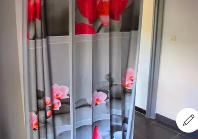 a curtain with red flowers in a room at F1 calme et proche des plages in Coti-Chiavari