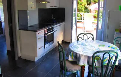 a kitchen with a table and a table and chairs at F1 calme et proche des plages in Coti-Chiavari