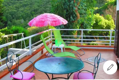 a patio with chairs and a table and an umbrella at F1 calme et proche des plages in Coti-Chiavari