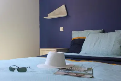 a bedroom with a bed with a hat and glasses at MINI VILLA PALOMBAGGIA - Piscine chauffée in Porto-Vecchio