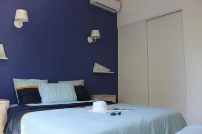 a blue bedroom with a bed with a blue wall at MINI VILLA PALOMBAGGIA - Piscine chauffée in Porto-Vecchio