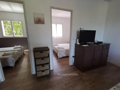 a room with a television on a dresser and a bedroom at Appartements avec jardin entre Porto-Vecchio et Figari - Casa Mattiste in Sotta