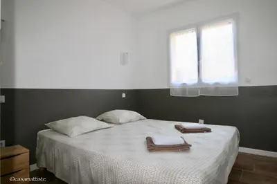 a bedroom with a bed with two towels on it at Appartements avec jardin entre Porto-Vecchio et Figari - Casa Mattiste in Sotta