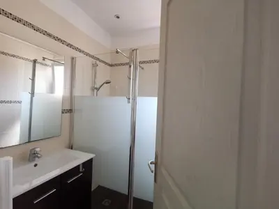 a bathroom with a sink and a shower with a mirror at Appartements avec jardin entre Porto-Vecchio et Figari - Casa Mattiste in Sotta
