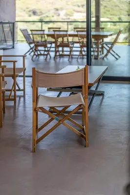 a wooden chair and table in a room with tables and chairs at Les Villas de Lorello in Porticcio