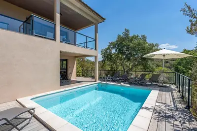 a swimming pool in the backyard of a house at Les Villas de Lorello in Porticcio