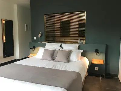 a bedroom with a large bed with white sheets and pillows at Villa Limone, maison d'hôtes in Calenzana