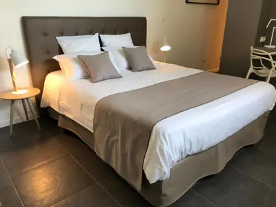 a large bed with white sheets and pillows in a bedroom at Villa Limone, maison d'hôtes in Calenzana