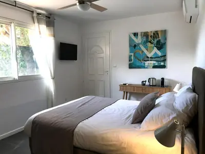 a bedroom with a bed and a ceiling fan at Villa Limone, maison d'hôtes in Calenzana