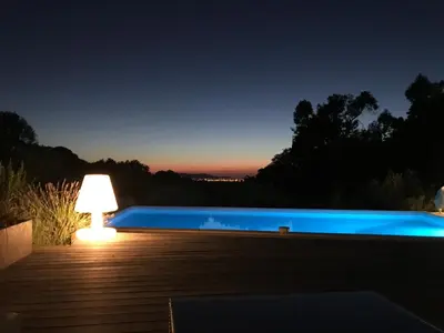 a night view of a swimming pool with a lamp at Villa Limone, maison d'hôtes in Calenzana