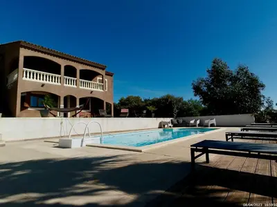 a swimming pool in front of a house at Bas de villa vue mer & piscine in Coti-Chiavari