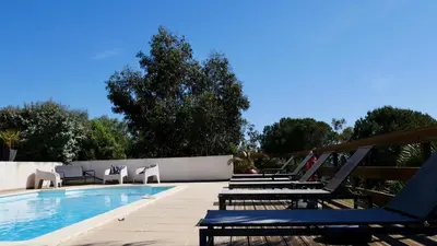 a pool with chaise lounge chairs and a swimming pool at Bas de villa vue mer & piscine in Coti-Chiavari