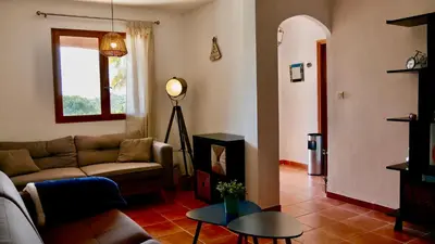 a living room with a couch and a table at Bas de villa vue mer & piscine in Coti-Chiavari