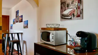 a microwave sitting on a table with a tv at Bas de villa vue mer & piscine in Coti-Chiavari