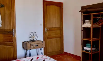a room with a wooden door and a shelf at Bas de villa vue mer & piscine in Coti-Chiavari