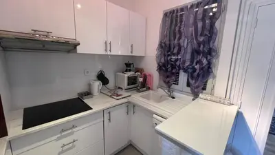 a small kitchen with white cabinets and a sink at Un Havre de Paix aux Sanguinaires in Ajaccio
