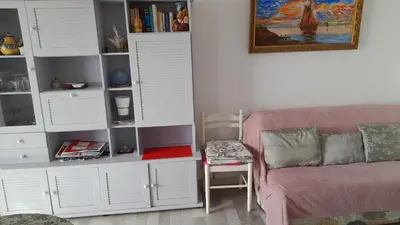 a living room with a pink couch and white cabinets at Un Havre de Paix aux Sanguinaires in Ajaccio