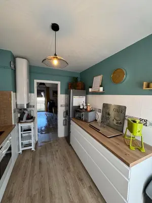 a kitchen with green walls and a counter top at T3 Cosy in Ajaccio