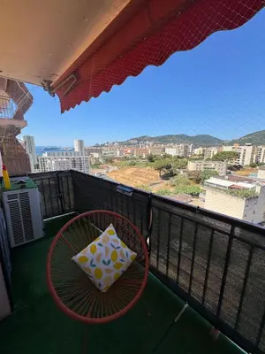 a chair and pillow on a balcony with a view at T3 Cosy in Ajaccio