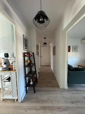 a hallway with a room with a couch and a chandelier at T3 Cosy in Ajaccio