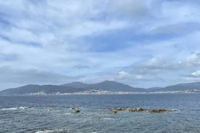 a large body of water with mountains in the background at Appartement cosy, vue mer à 5 min à pied de la mer in Grosseto-Prugna