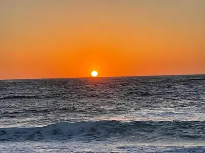 a sunset over the ocean with the sun setting at Appartement cosy, vue mer à 5 min à pied de la mer in Grosseto-Prugna