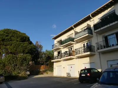 a car parked in a parking lot next to a building at Appartement cosy, vue mer à 5 min à pied de la mer in Grosseto-Prugna