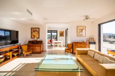 a living room with a couch and a glass table at Appart Stella résidence standing, vue panoramique in Porto-Vecchio