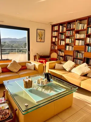a living room with couches and a glass table at Appart Stella résidence standing, vue panoramique in Porto-Vecchio