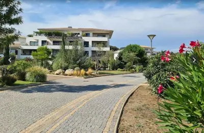 an empty road with flowers and a building at Appart Stella résidence standing, vue panoramique in Porto-Vecchio