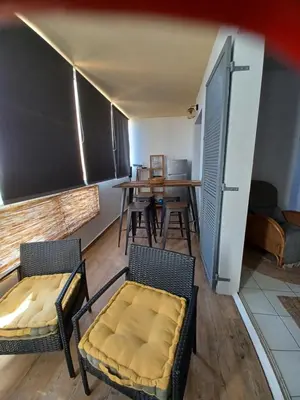 a room with two chairs and a table and a dining room at Les crêtes , magnifique T2 4 pers Route des Sanguinaires in Ajaccio