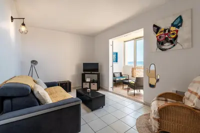 a living room with a blue couch and a television at Les crêtes , magnifique T2 4 pers Route des Sanguinaires in Ajaccio