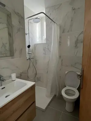 a bathroom with a sink and a toilet and a shower at T2 vue mer - entre aéroport et centre-ville in Ajaccio