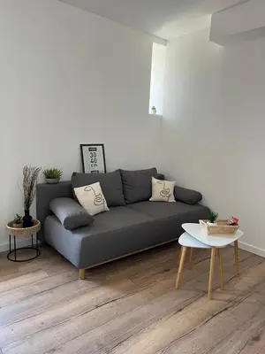 a living room with a gray couch and a table at T2 vue mer - entre aéroport et centre-ville in Ajaccio