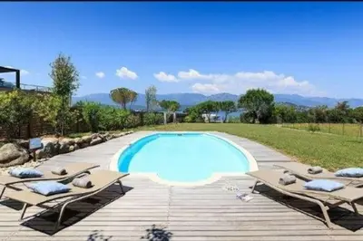 a swimming pool with two lounge chairs next to it at Villa Casetta Bianca 2 chambres, Piscine et accès mer in Porto-Vecchio