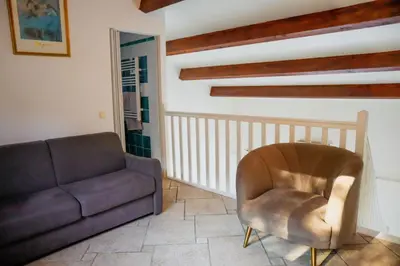 a living room with a couch and a chair at Villa Casetta Bianca 2 chambres, Piscine et accès mer in Porto-Vecchio