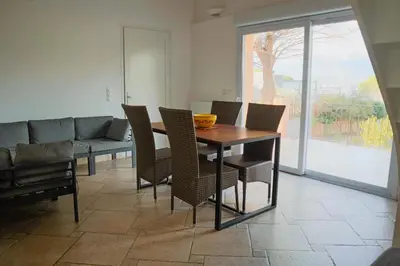 a dining room with a table and chairs and a couch at Villa Casetta Bianca 2 chambres, Piscine et accès mer in Porto-Vecchio