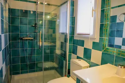 a green tiled bathroom with a toilet and a shower at Villa Casetta Bianca 2 chambres, Piscine et accès mer in Porto-Vecchio
