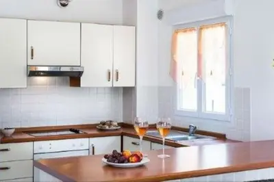 a kitchen with a table with two glasses of wine at Villa Casetta Bianca 2 chambres, Piscine et accès mer in Porto-Vecchio
