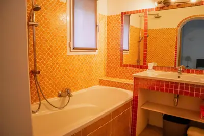 a bathroom with a bath tub and a sink at Villa Casetta Bianca 2 chambres, Piscine et accès mer in Porto-Vecchio