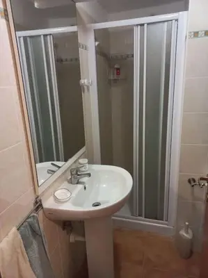 a bathroom with a sink and a shower with a mirror at Appartement de vacances Marine de Bravone - Corse in Linguizzetta