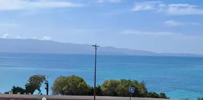 a street light on the side of a road near the ocean at Superbe Pieds dans l eau ajaccio face à la mer plage de sable fin route des îles des sanguinaires in Ajaccio